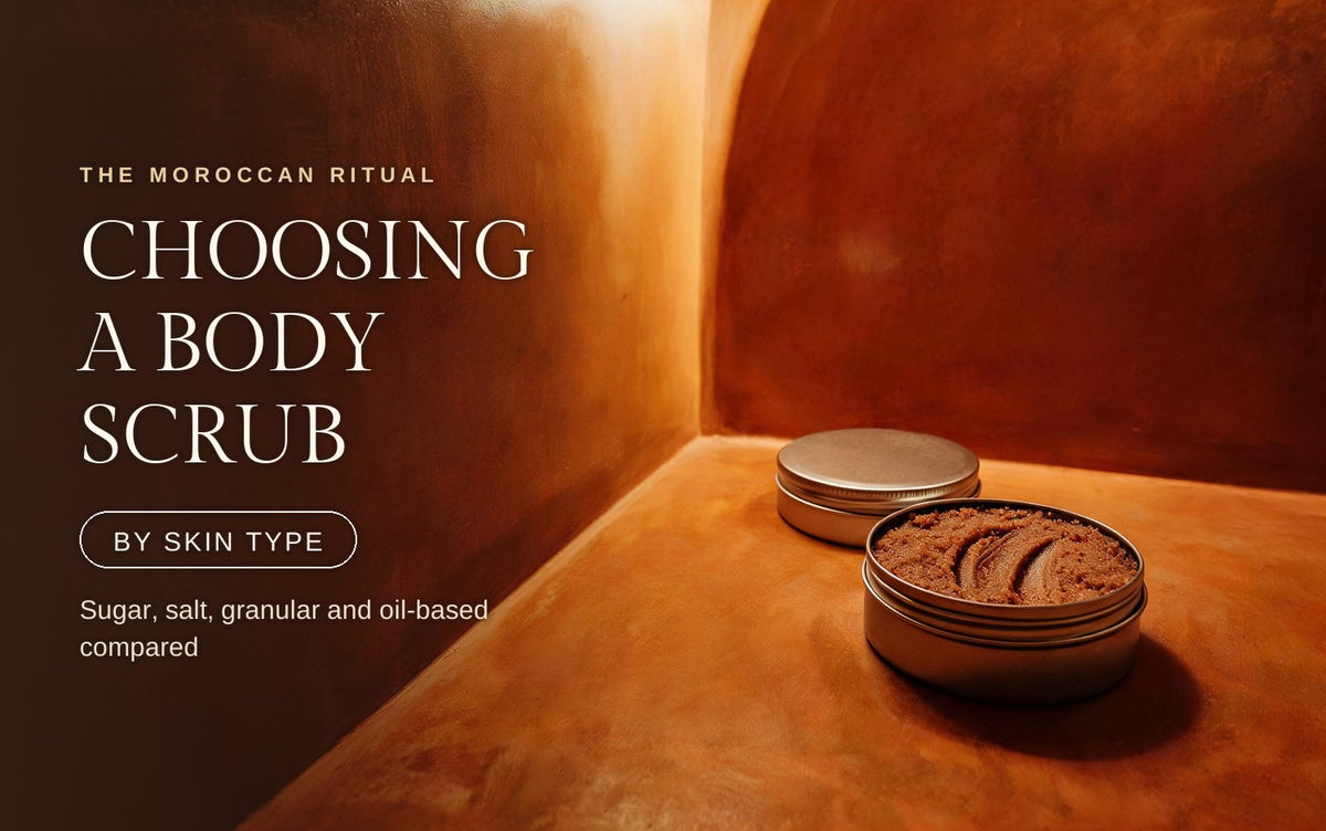 An open metal tin of coarse granular body scrub with swipe grooves drawn through its surface, a second closed tin resting behind it on a warm clay ledge in a shadowed tadelakt hammam corner