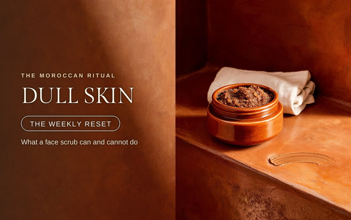 Glazed terracotta pot of oil-based face scrub with a swipe on the clay ledge and folded cream linen behind