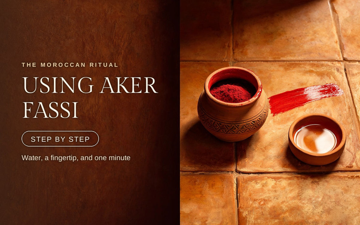 Terracotta aker fassi pot with a single red pigment swipe across warm clay tile beside a shallow dish of water