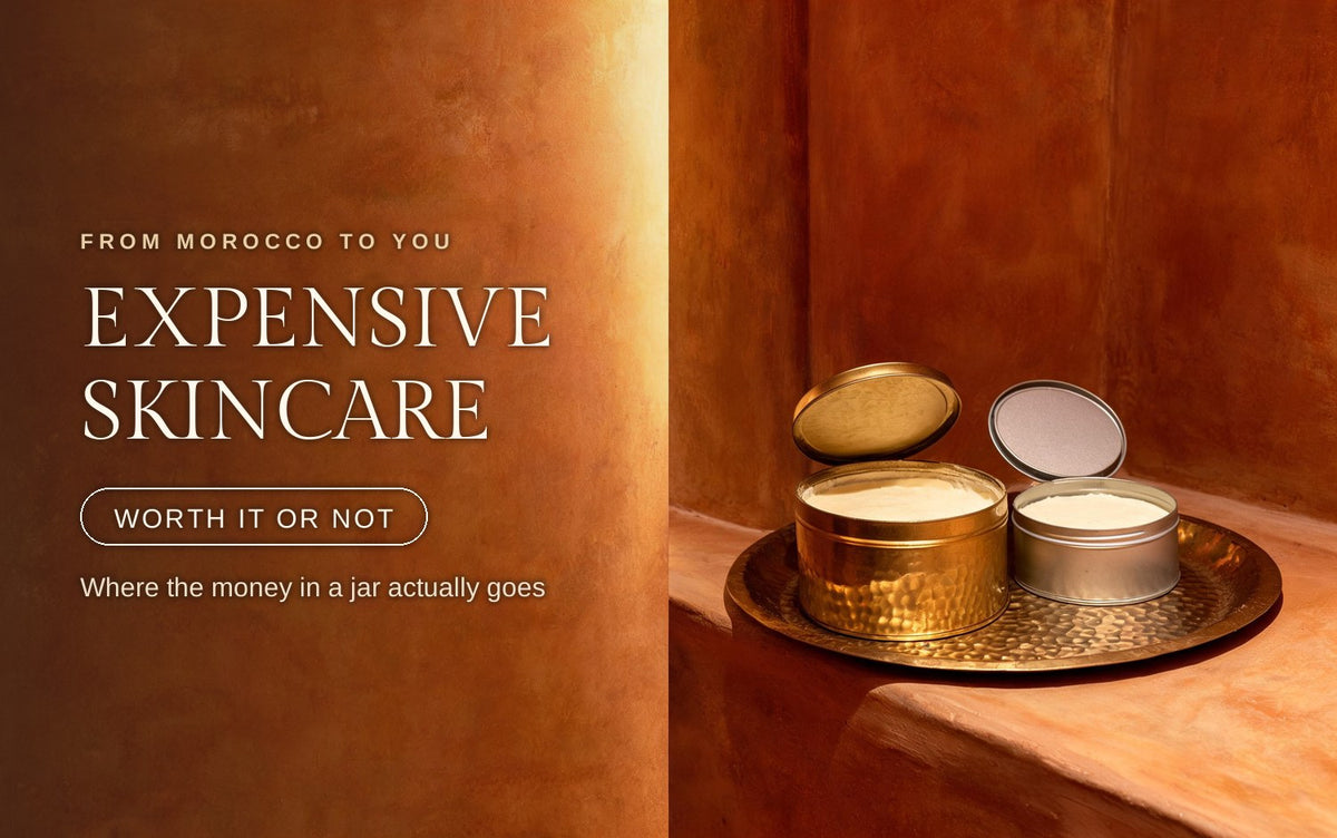 Two open metal tins side by side on a hammered brass tray on a warm clay ledge, one thick hammered gold tin with a deep lid propped behind it and one thin plain tin with a shallow lid, both filled to the rim with the same pale cream