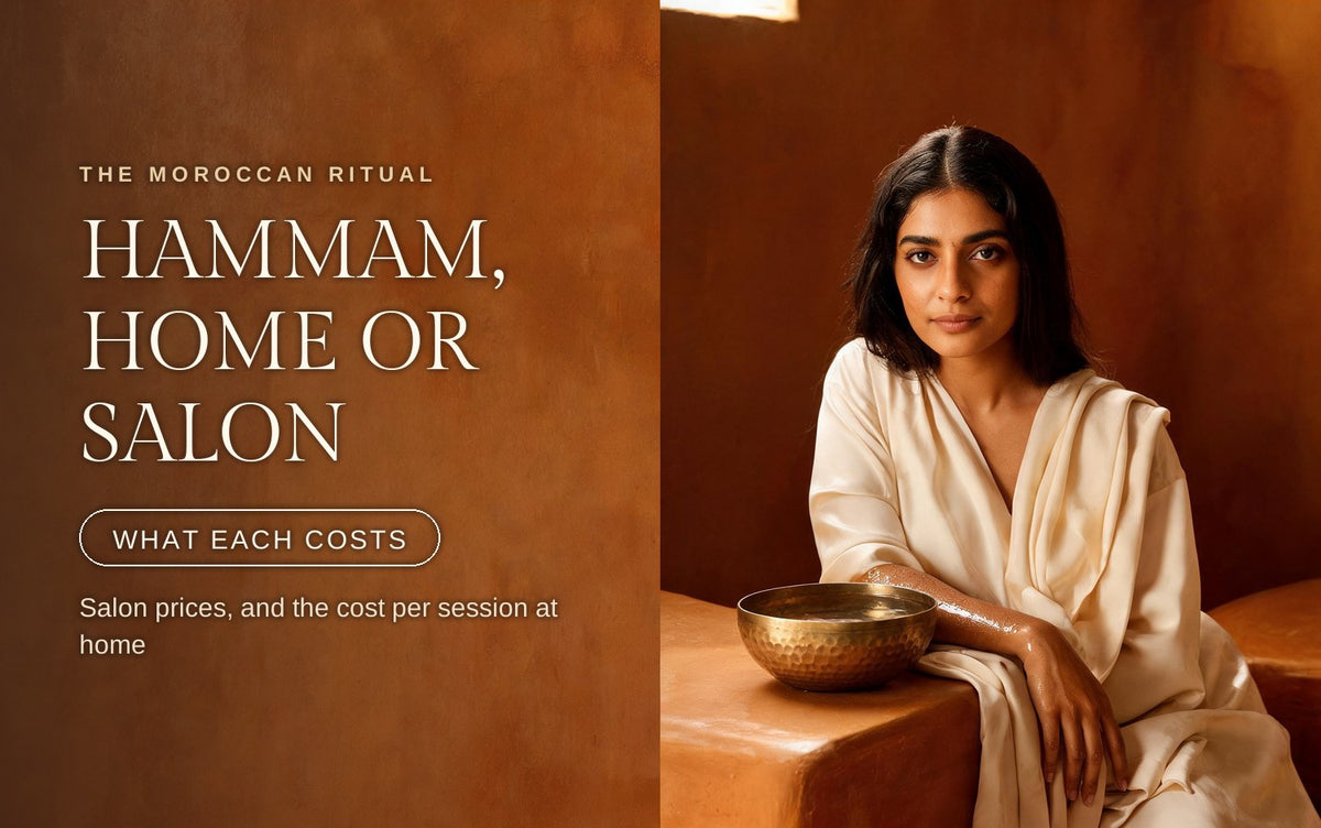 A woman in a cream silk robe seated on a warm tadelakt bench in amber hammam light, water still beaded on her forearm, a hammered brass bowl of water on the ledge beside her