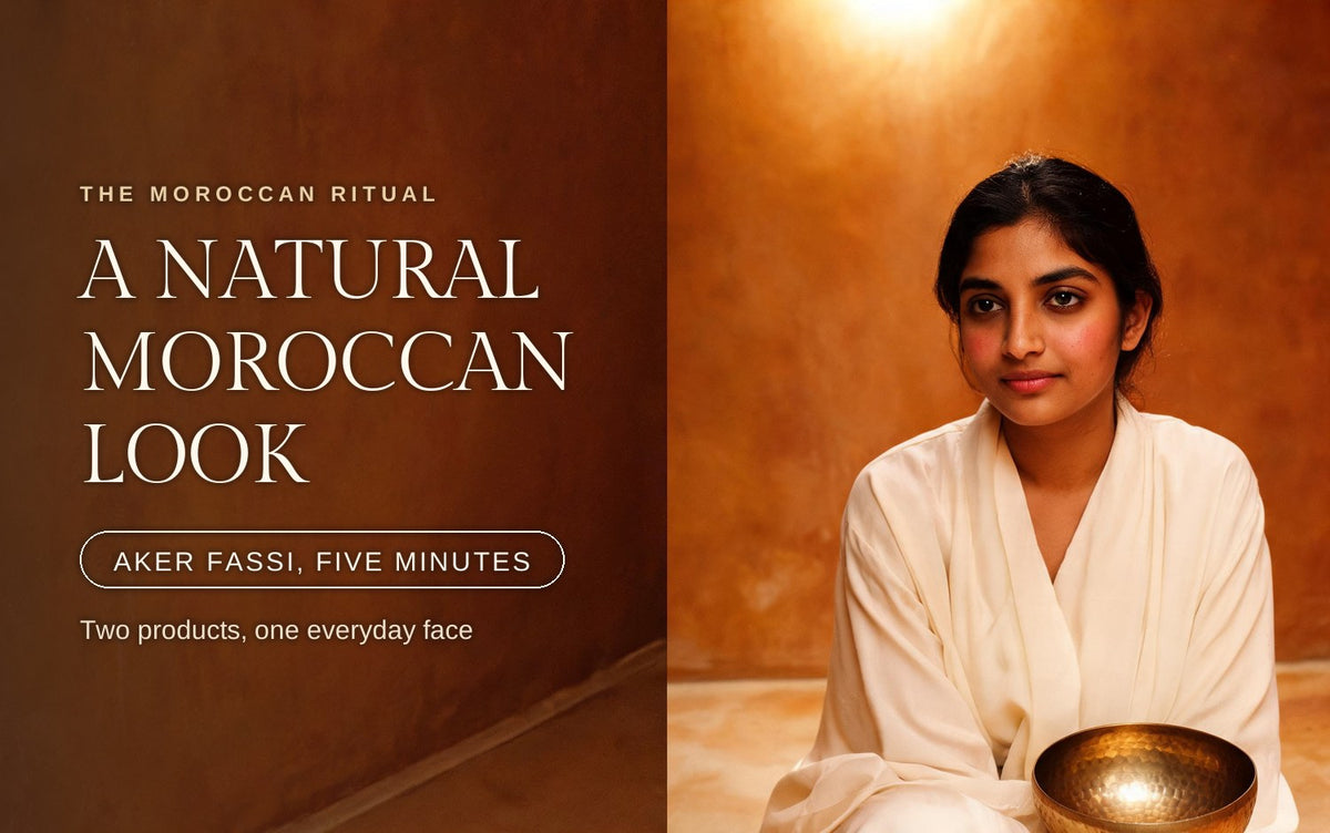 Indian woman in a cream silk robe with a soft rose flush, seated in a warm hammam beside a brass bowl